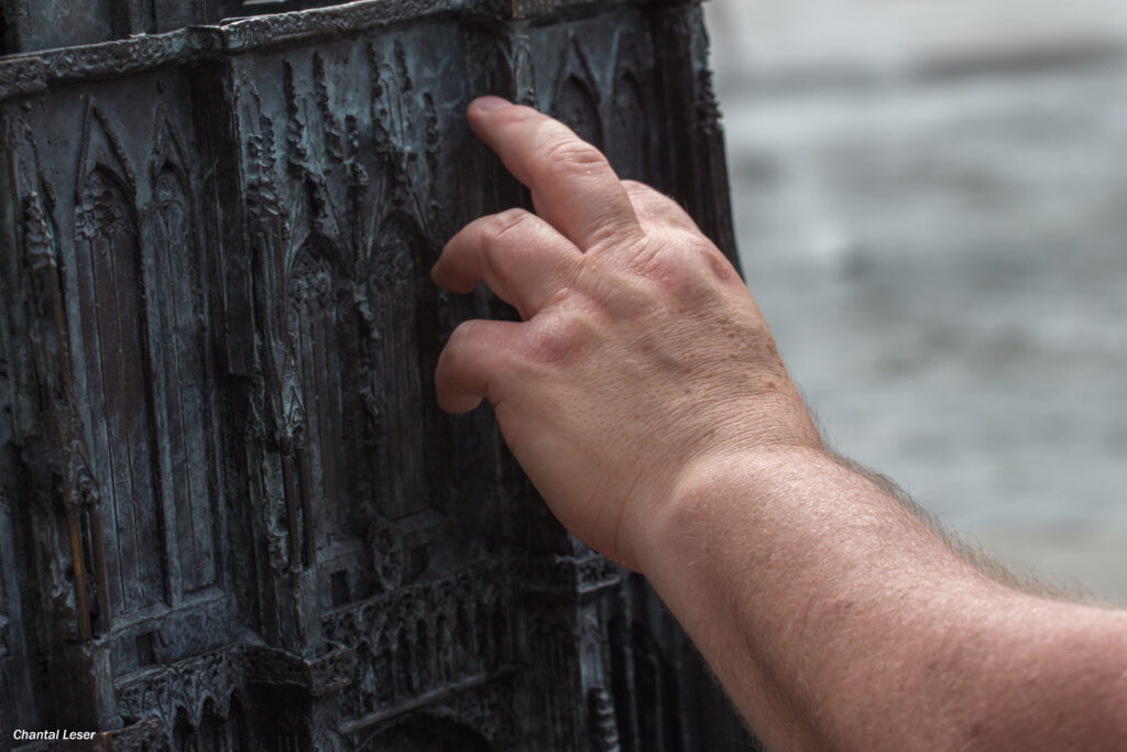 Photo de la main de Teddy qui touche la maquette de la cathédrale de Strasbourg