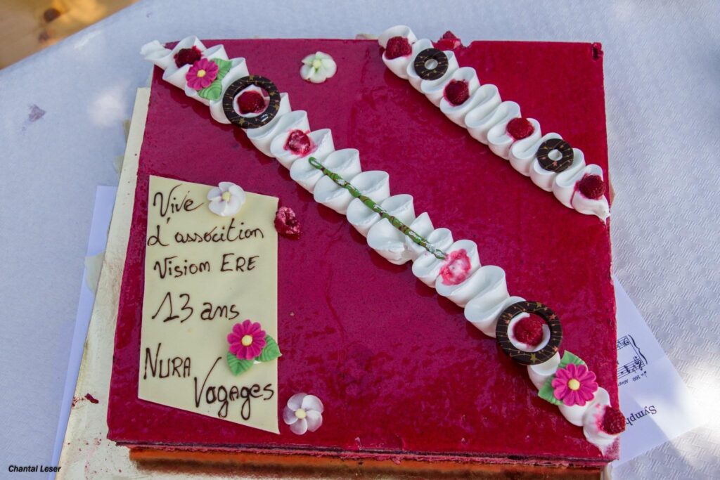 Gateau offert par Marie-Eve sur lequel est écrit Vive l'association Vision'ère 13 ans Nura Voyages à l'occasion de l'anniversaire de Nura Voyages