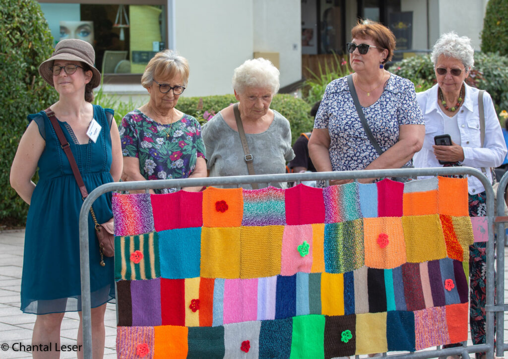 Le gang des tricoteuses et Julie du Phare devant une barrière recouverte de carrés de tricot