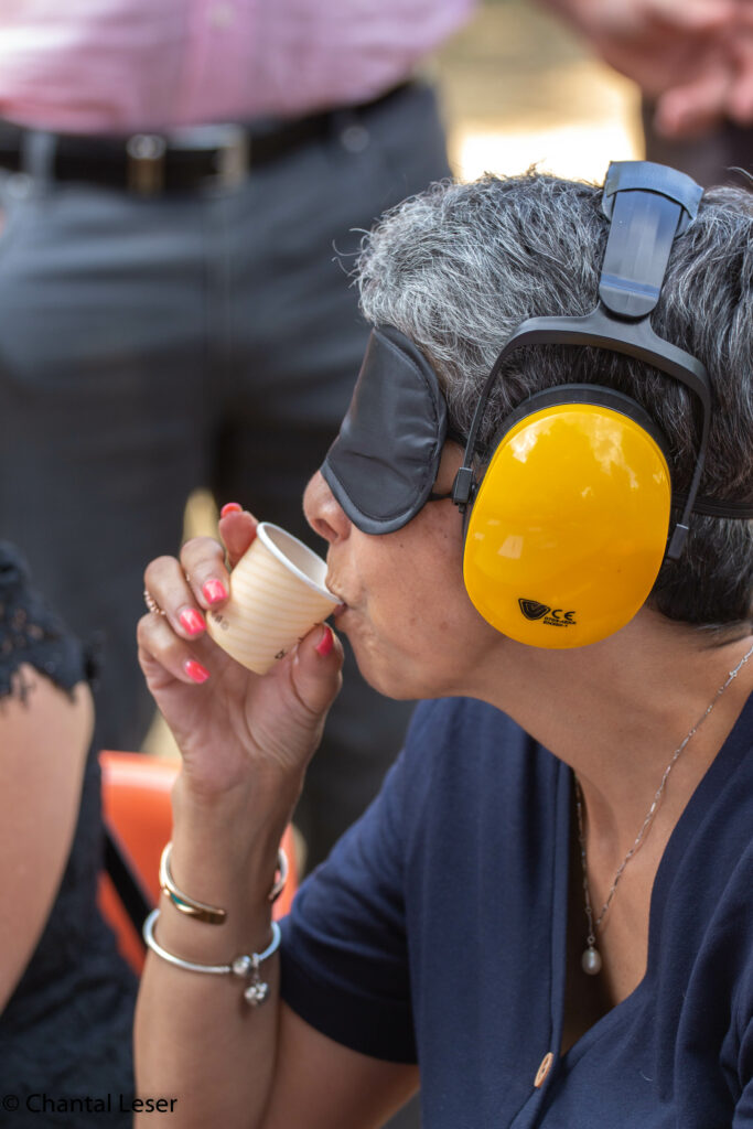Nora Hottinger du Phare en pleine degustation de nourriture et de boissons avec un masque sur les yeux et un casque sur les oreilles
