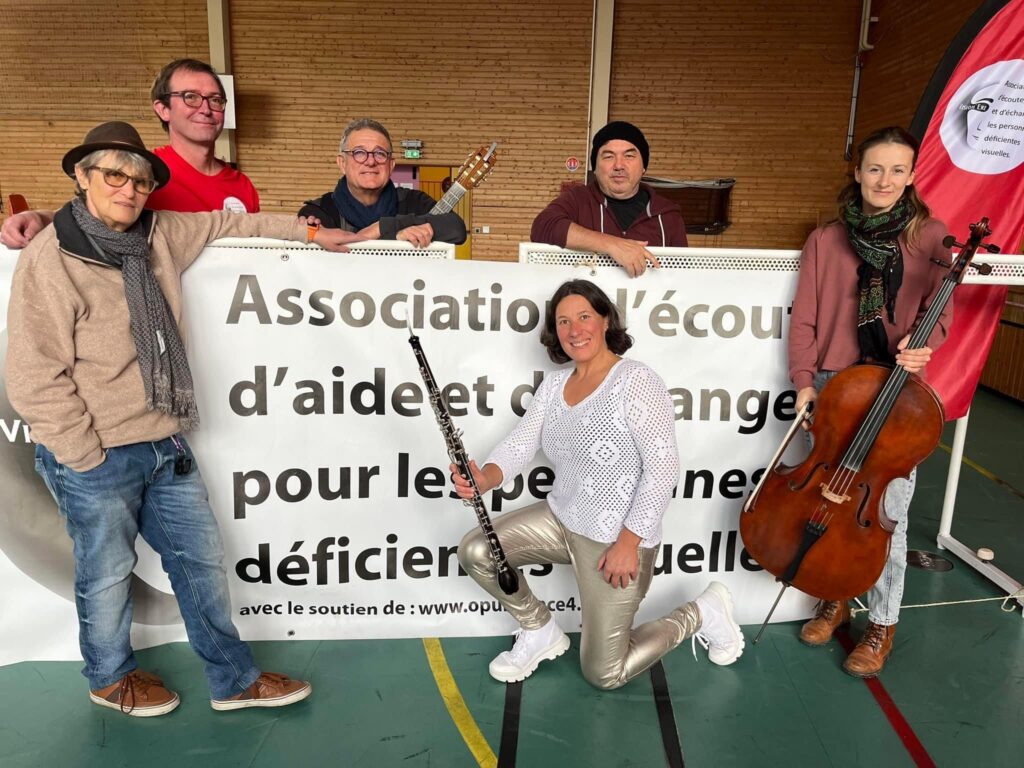 Photo du groupe Viz Trio devant la banderole Vision'ère avec Chantal Leser et Sébastien Wiss