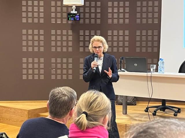 Photo du Professeur Hélène Dollfus debout, micro à la main répondant aux questions du public