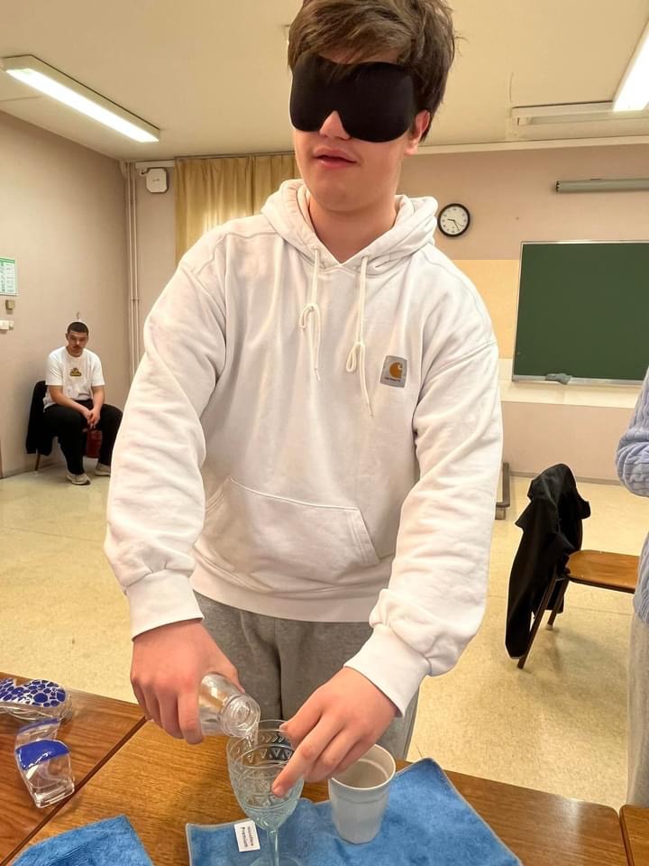 Photo d'un jeune qui se verse un verre d'eau avec les yeux bandés