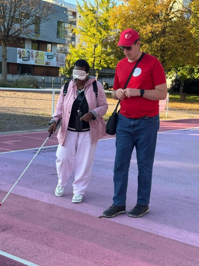 Matthieu guide une dame qui essai le maniement de la canne blanche