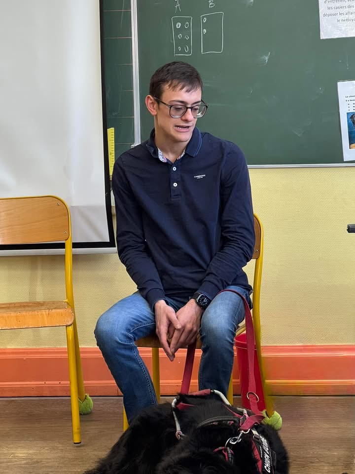 Bastien assis devant les élèves et en train de leur parler