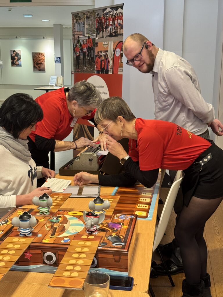 Dominique, Rachel et Sébastien font découvrir le braille à une visiteuse du stand