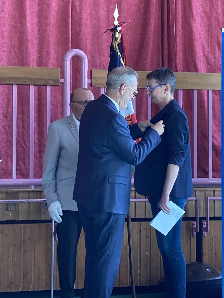 Fabian Jordan en train de remettre à Nathalie Jeker-Wasmer l'insigne de Chevalier de la Légion d'Honneur