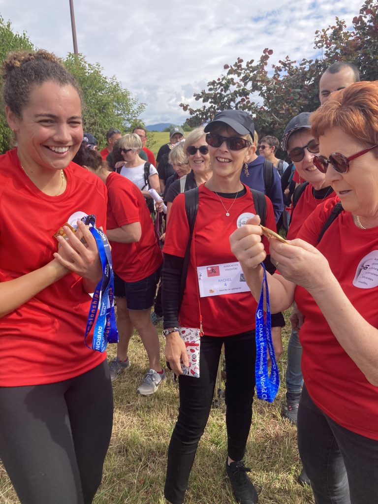 Notre marraine Louise qui tient ses médailles sur son coeur et qui rigole avec Rachel, Dominique et Anne-Marie qui découvrent les médailles
