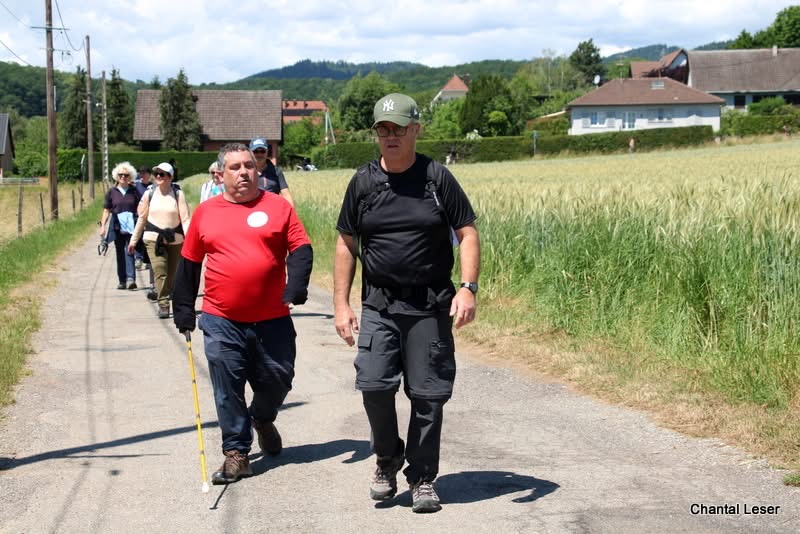 Plusieurs marcheurs en train d'arriver au stade dont Teddy au premier plan
