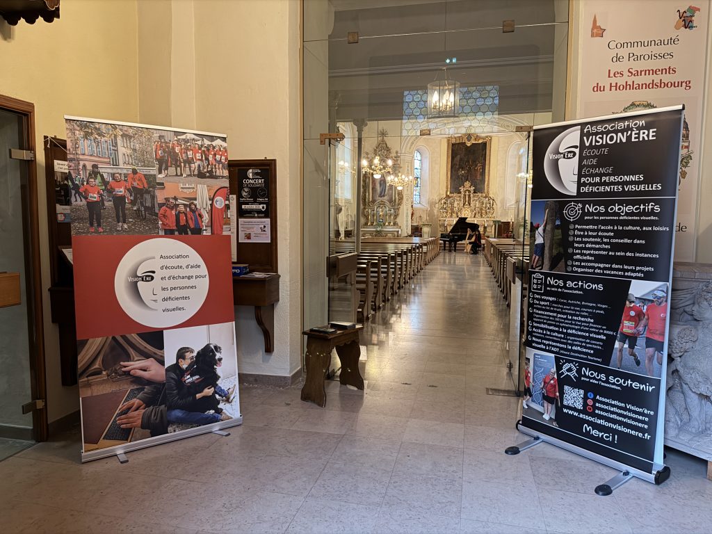 Vue de l'intérieur de l'église depuis l'entrée avec les kakémono Vision'ère de part et d'autres